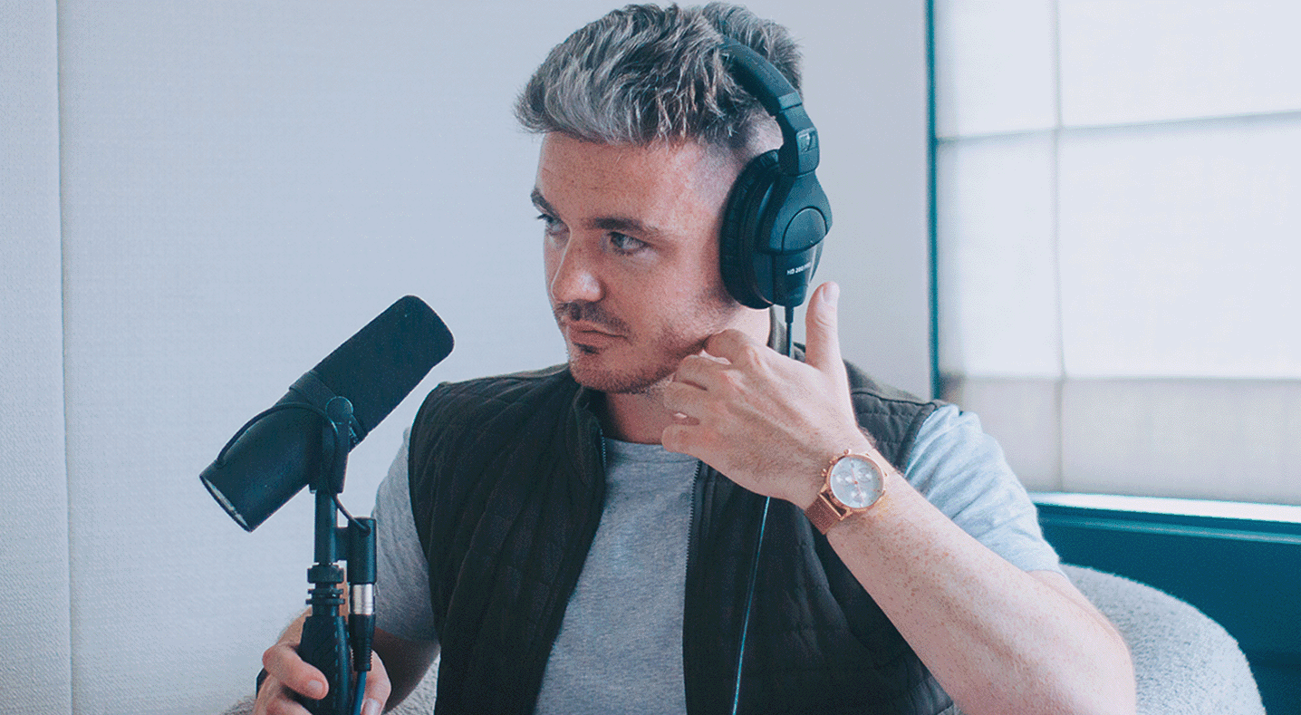 Cornelius McGrath in headphones at a podcast microphone